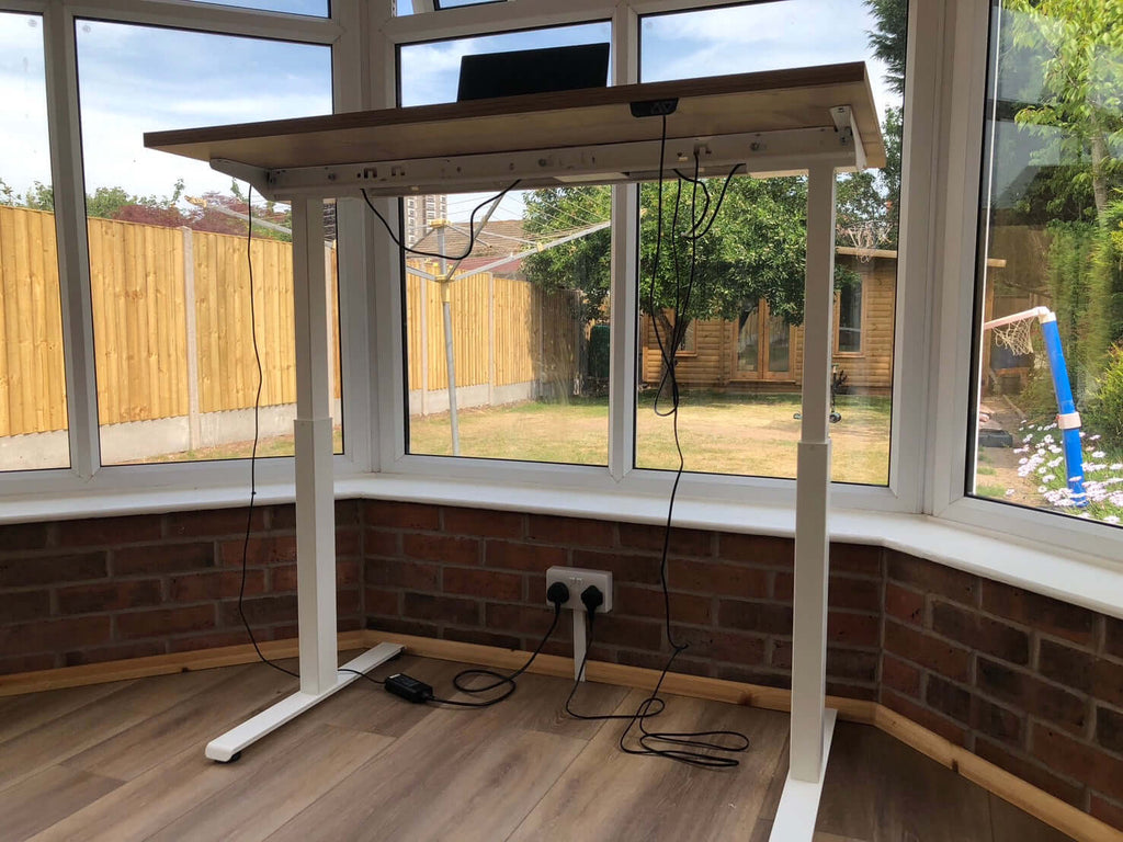 iLohas 2 Dual Motor Electric Standing Desk in a sunlit room showcasing its dual motor electric standing desk features.